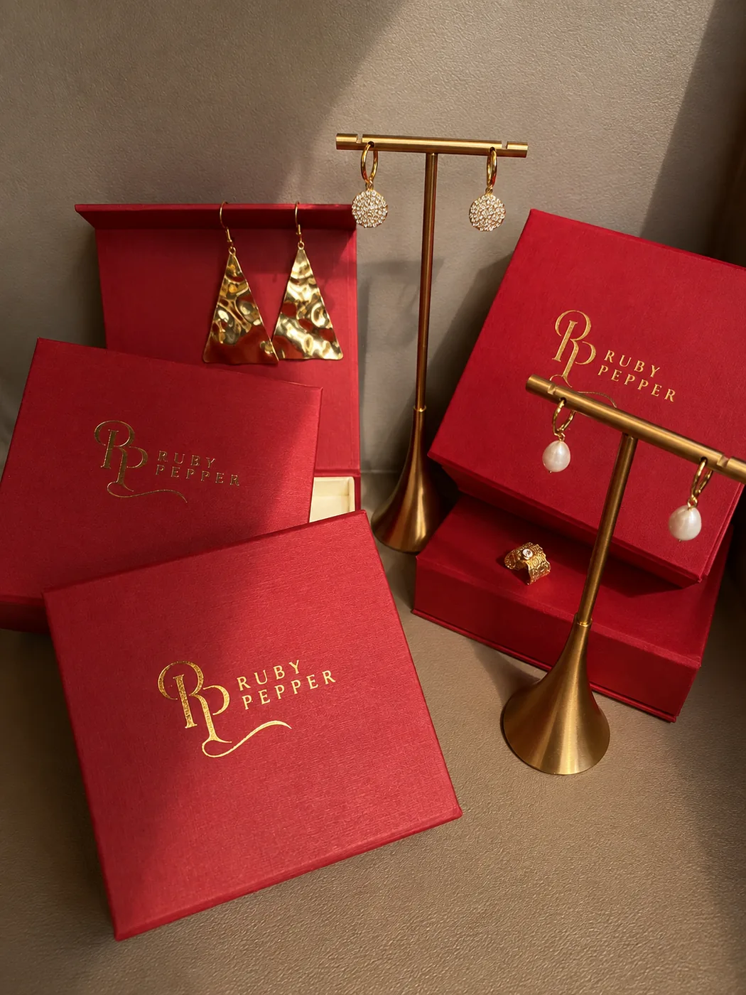 Ruby Pepper boxes with earrings on a gold stand