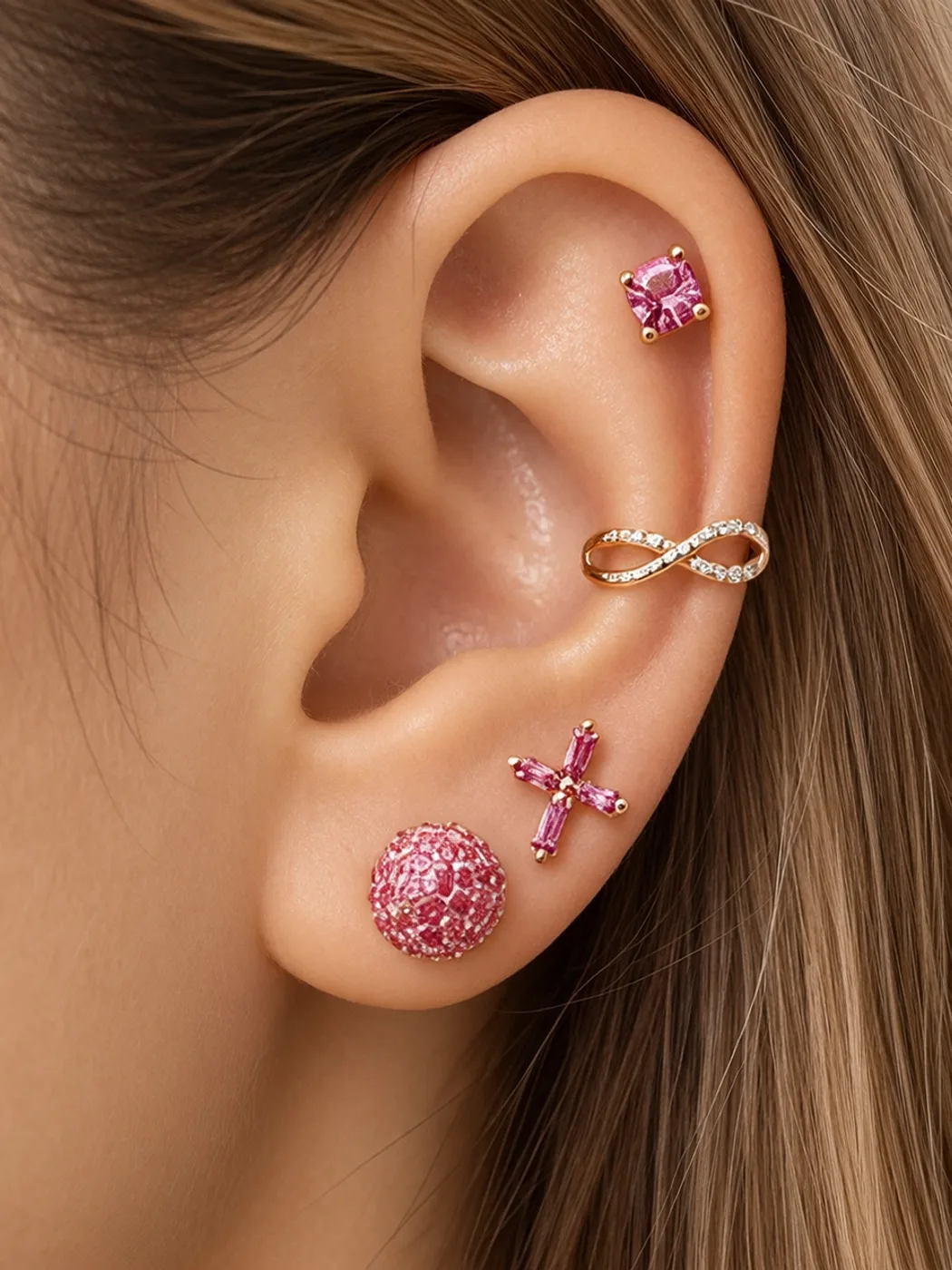 Pink crystal ear stack with a rose gold cuff, cross stud and pavé ball
